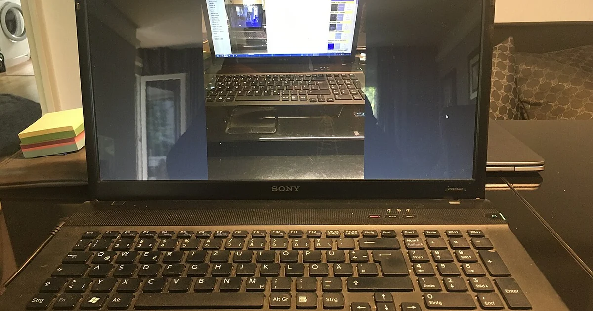 Image with nested realities of a laptop showing the image of the same laptop showing a Wikimedia Commons image of the laptop